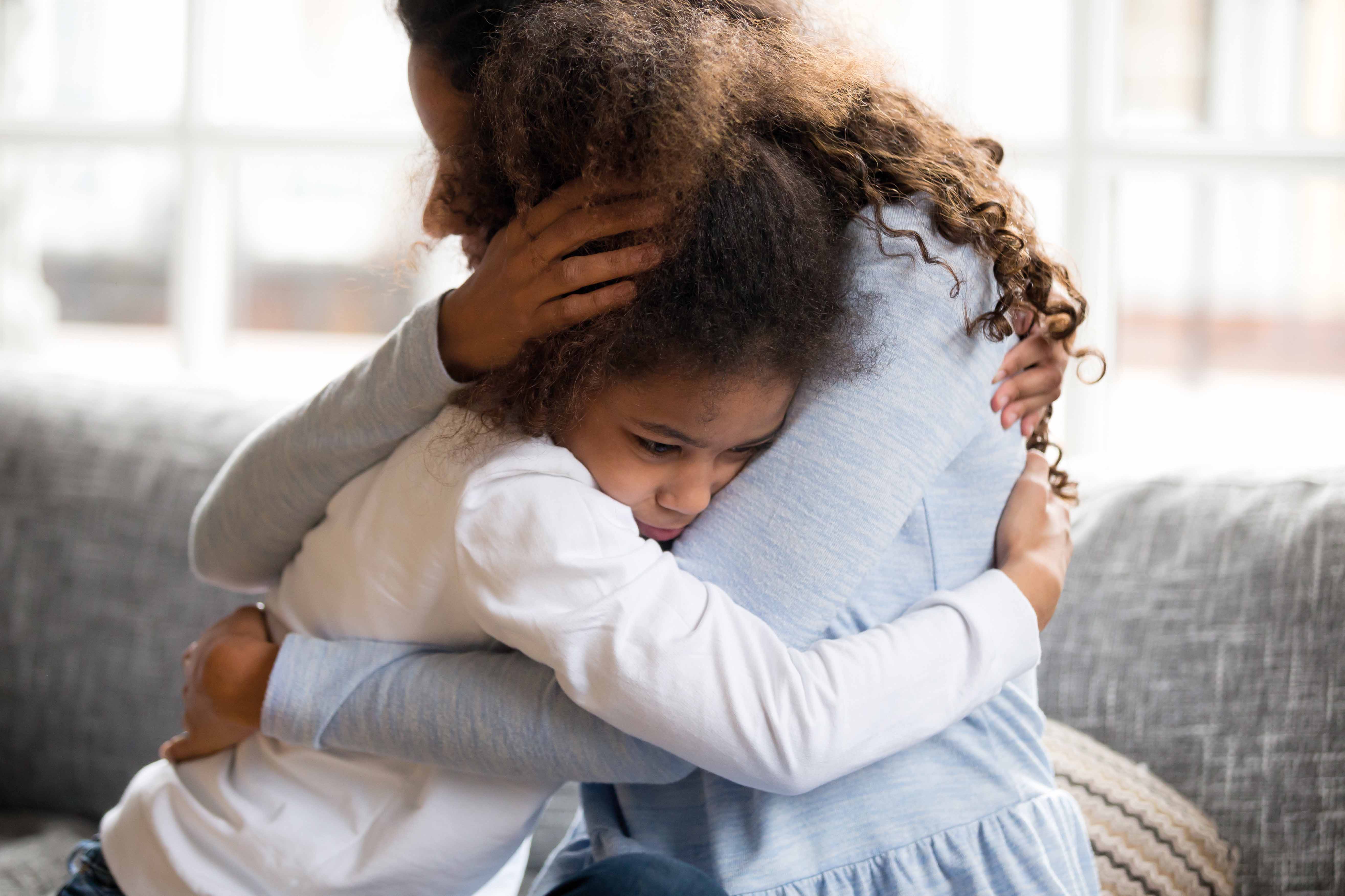 2 Mum hugging upset child on the sofa LR Mum hugging upset child